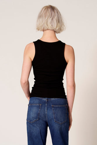 Zwarte singlet van Clouds of Fashion, met ribstructuur, gedragen met een donkerblauwe jeans.