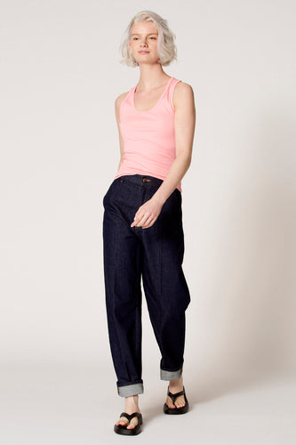 Roze singlet van Clouds of Fashion, gedragen met donkere jeans met omslag en zwarte sandalen.