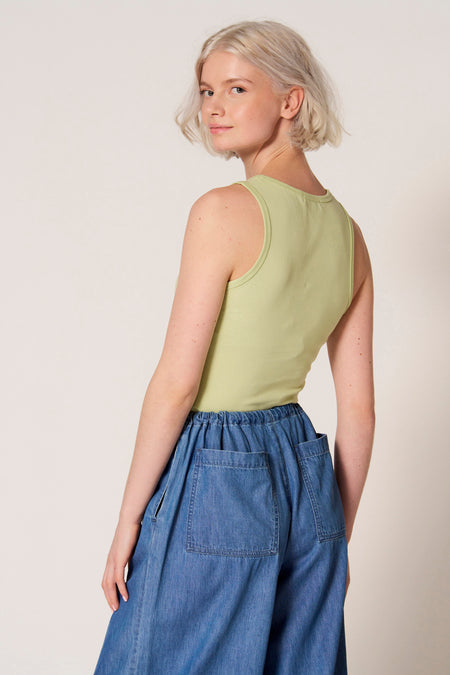 Groene singlet van Clouds of Fashion, met ronde halslijn, gedragen met wijde, blauwe denim broek.
