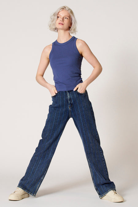 Blauwe singlet van Clouds of Fashion, met ronde halslijn en gedragen met gestreepte jeans en crèmekleurige sneakers.