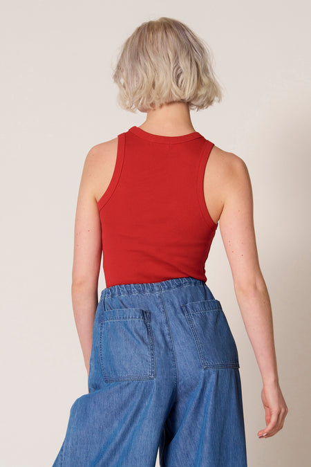 Rode singlet van Clouds of Fashion, met een ronde hals en zichtbare jeans broek met zakken.
