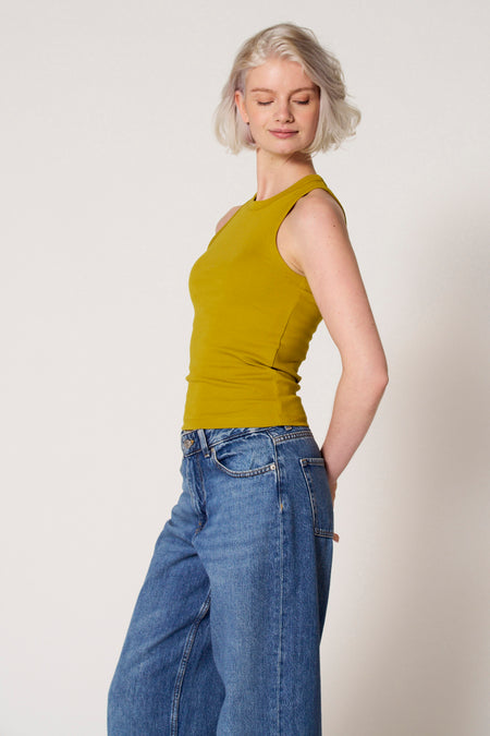 Groene singlet van Clouds of Fashion, gedragen met blauwe jeans.