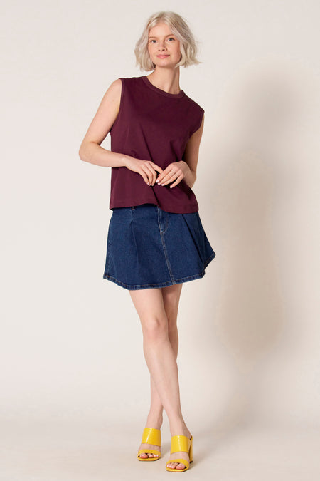 Paarse singlet van Clouds of Fashion, gedragen met een blauwe denim rok en gele sandalen.