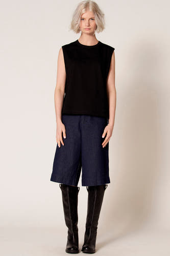 Zwarte singlet van Clouds of Fashion, gedragen met donkerblauwe culottes en zwarte leren kniehoge laarzen.