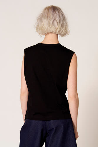 Zwarte singlet van Clouds of Fashion, gezien van achteren, gecombineerd met een donkerblauwe broek.

