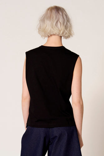 Zwarte singlet van Clouds of Fashion, gezien van achteren, gecombineerd met een donkerblauwe broek.
