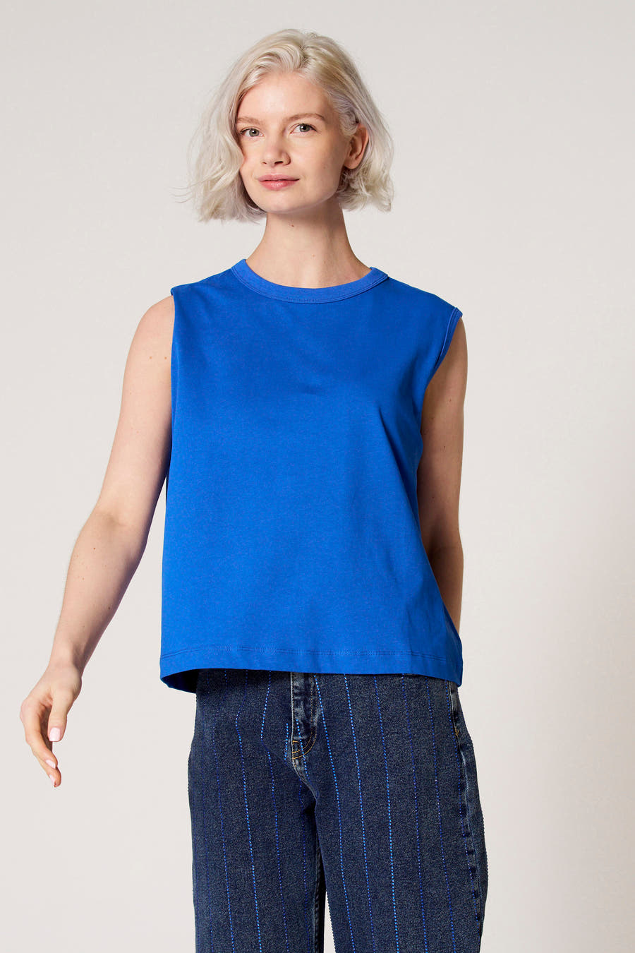 Blauwe singlet van Clouds of Fashion, met denim broek met blauwe strepen.
