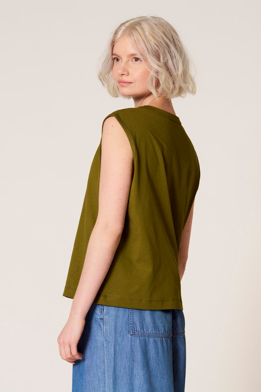 Groene singlet van Clouds of Fashion, met afgeronde hals en mouwloos design, gedragen met een blauwe rok.