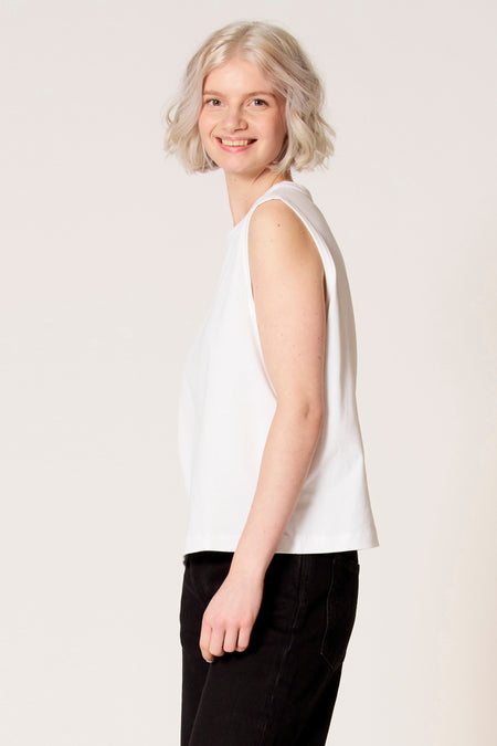 Witte singlet van Clouds of Fashion, met een eenvoudig design, gedragen met een zwarte broek.