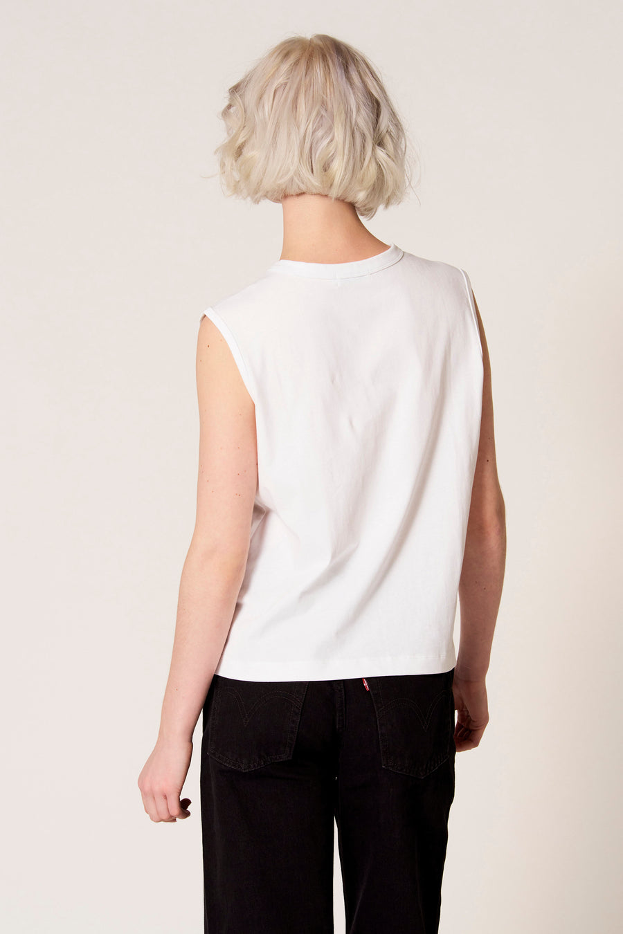 Débardeur blanc de Clouds of Fashion, vu de dos, combiné avec un pantalon noir.