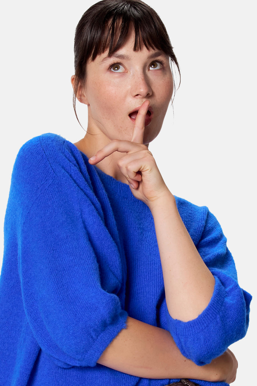 Blauwe korte mouwen trui van Clouds of Fashion, gebreid met ruime pasvorm, model in zijprofiel met vinger op lippen