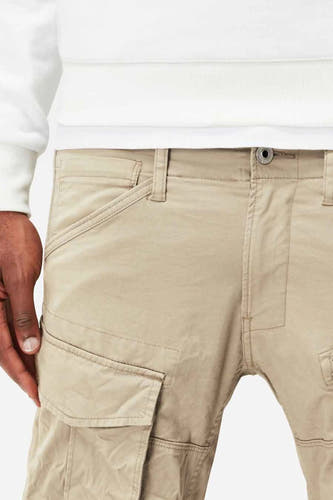 Jean cargo beige de G-Star RAW, avec poches et boutons, ceinture élastiquée et une partie d'un t-shirt blanc.