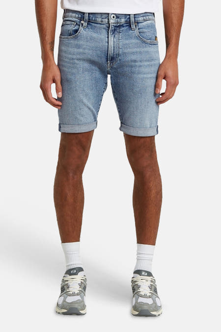 Lichtblauwe jeansshort van G-Star RAW met opgerolde pijpen, gedragen met een wit T-shirt en grijze sneakers.