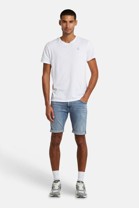 Lichtblauwe denim short van G-Star RAW met omgeslagen pijpen, gedragen door een man met wit T-shirt en sneakers.