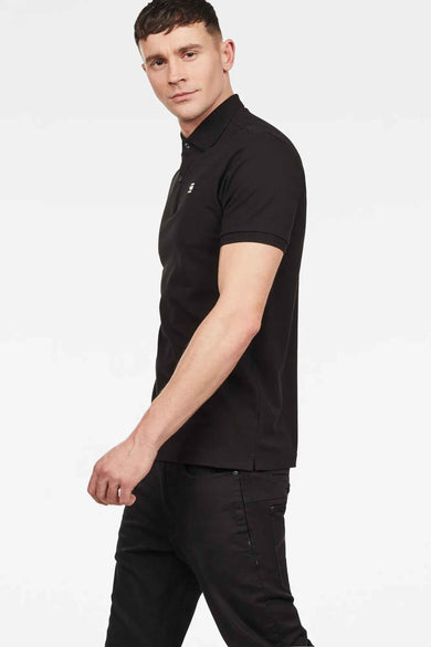 Zwarte polo van G-Star RAW, zijdelings weergegeven, gecombineerd met een zwarte jeans.