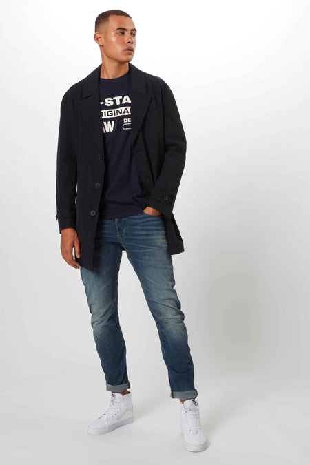 Denim T-shirt van G-Star RAW, met een logo opdruk, gecombineerd met een donkerblauwe jas en jeans.