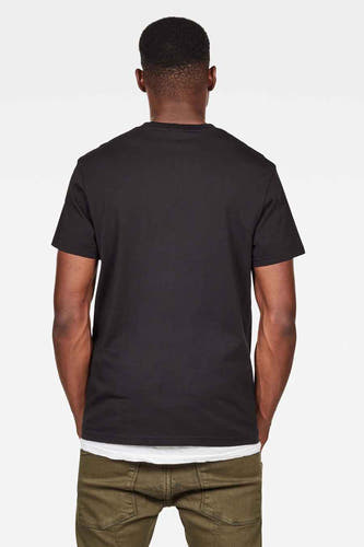 Zwart T-shirt van G-Star RAW, met korte mouwen, gezien van achteren, gecombineerd met een witte top en groene broek.

