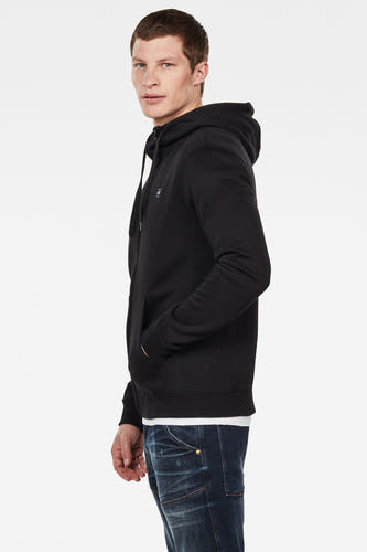 Zwart gilet van G-Star RAW, met capuchon en zakken, gedragen over een wit shirt en blauwe jeans, in zijaanzicht.
