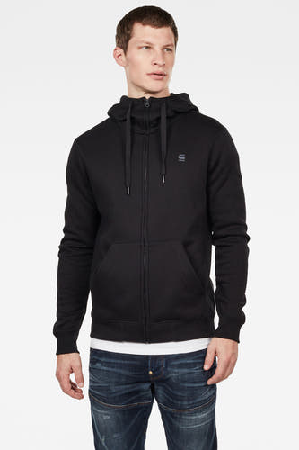 Zwarte sweater van G-Star RAW, met capuchon, rits en zakken, gedragen over een wit T-shirt en blauwe jeans.
