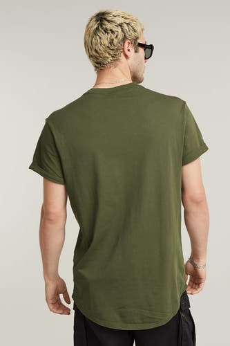 Groen T-shirt van G-Star RAW, gezien van achteren met opgerolde mouwen en een zwarte broek.
