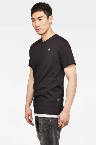 Zwart T-shirt van G-Star RAW, met korte mouwen en een kleine logo-opdruk, gedragen met een grijze jeans.
