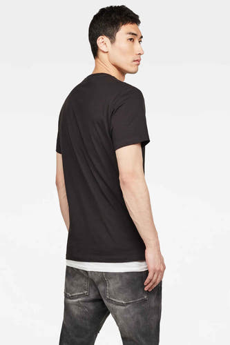 Zwart T-shirt van G-Star RAW, getoond van achteren, gecombineerd met een wit hemd en grijze jeans.