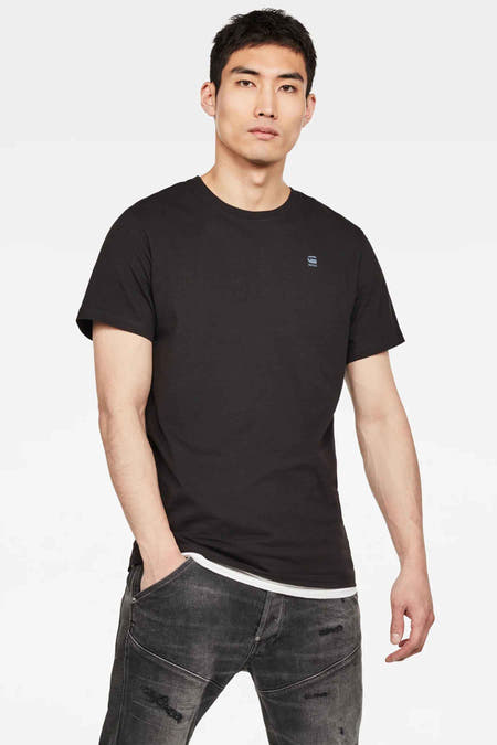 T-shirt noir de G-Star RAW, à manches courtes, porté avec un pantalon de travail gris.