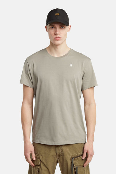 T-shirt gris à manches courtes de G-Star RAW, porté avec un chapeau noir et un pantalon cargo marron.