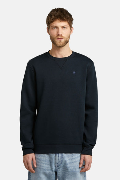 Blauwe sweater met ronde hals van G-Star RAW, effen en gedragen met een lichtblauwe jeans.
