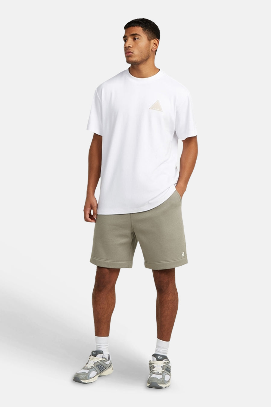 Short de survêtement gris de G-Star RAW avec logo sur la jambe, porté par un homme avec un T-shirt blanc et des baskets.