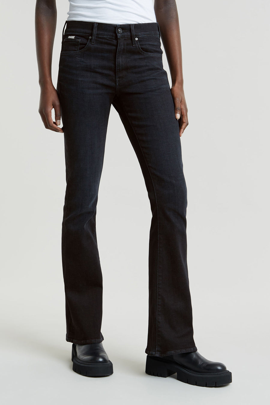Zwarte flared jeans van G-Star RAW, met subtiele wassing en gecombineerd met zwarte leren schoenen met dikke zolen.
