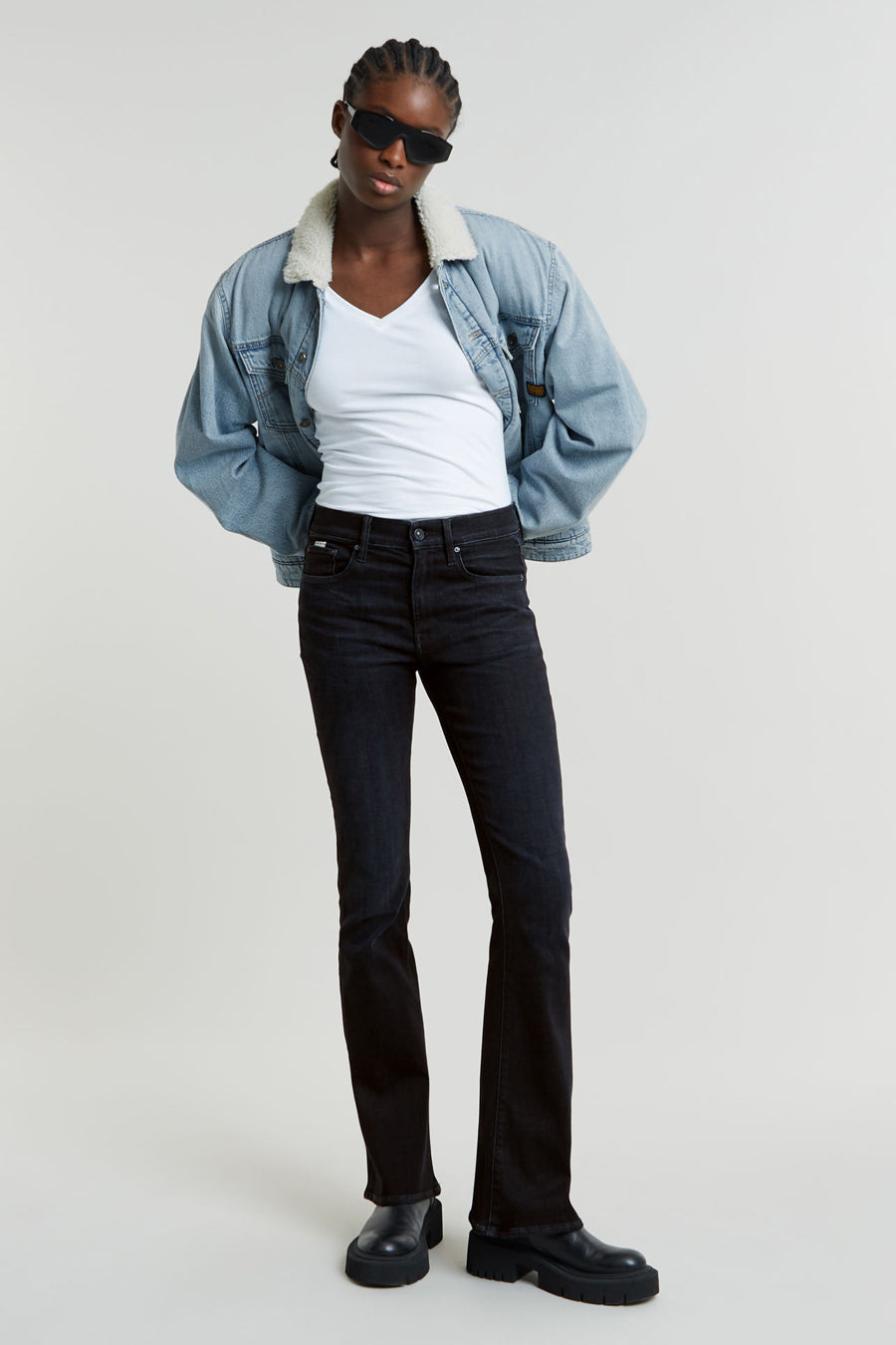Zwarte flared jeans van G-Star RAW, gecombineerd met een wit shirt, denim jack met teddy voering en zwarte schoenen.
