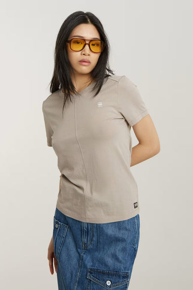 Ecrukleurig T-shirt met korte mouwen van G-Star RAW, met een verticale naad en gedragen met een blauwe rok.
