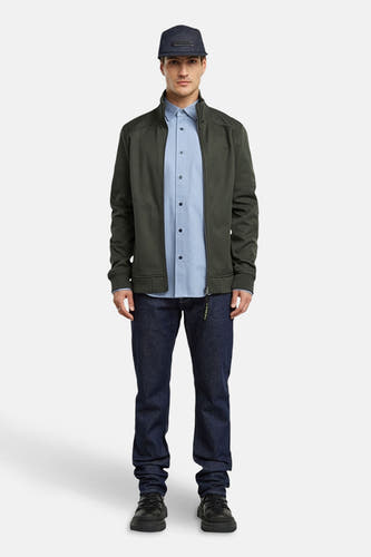 Blauw overhemd met lange mouwen van G-Star RAW, gedragen met een groene jas en donkerblauwe jeans.