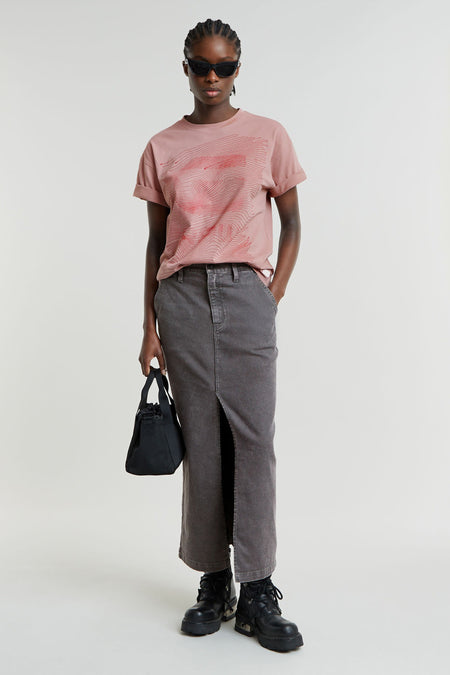 Lange rok van middengrijs denim van G-Star RAW met hoge split aan de voorkant, gestyled met een roze T-shirt en zwarte boots.