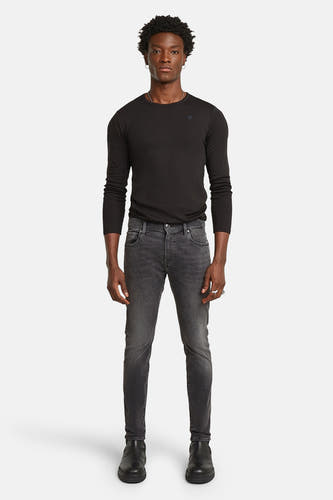 Skinny jeans van G-Star RAW, met een donkergrijze wassing en gedragen met een zwart shirt en laarzen.
