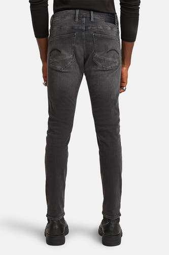 Grijze skinny jeans van G-Star RAW, achteraanzicht met zichtbare zakken en zwarte schoenen.