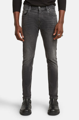 Grijze skinny jeans van G-Star RAW, met subtiele wassing en gedragen met zwarte boots.
