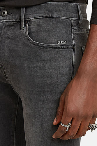 Grijze skinny jeans van G-Star RAW, met een hand en zilveren ringen.
