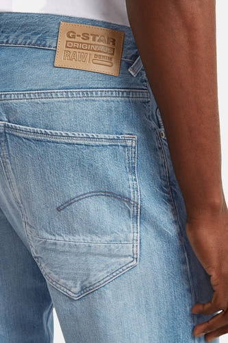 Jean tapered bleu clair en denim de G-Star RAW, avec poche arrière visible et étiquette en cuir de marque.