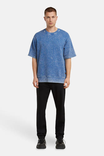 Blauwe sweater van G-Star RAW, gedragen met een zwarte jeans en zwarte schoenen.
