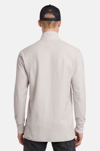 Ecru sweater van G-Star RAW, met lange mouwen en een subtiele textuur, gezien vanaf de achterkant, plus een pet.
