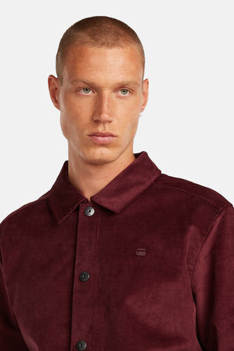 Rode jas van G-Star RAW, gemaakt van ribstof en met knoopsluiting, gedragen door een model.
