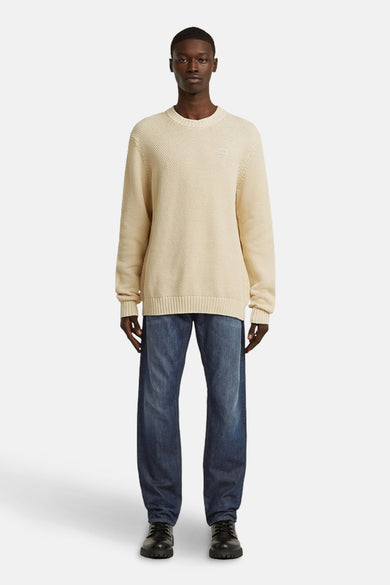 Ecru trui met ronde hals van G-Star RAW, gedragen met blauwe jeans en zwarte schoenen.