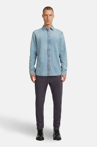 Jeanshemd van lichtblauw denim van G-Star RAW, met lange mouwen en knoopsluiting, gecombineerd met donkere broek en zwarte schoenen.
