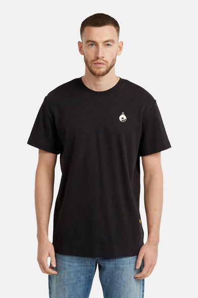 Zwart T-shirt van G-Star RAW met een klein wit logo op de borst, gedragen met blauwe jeans.
