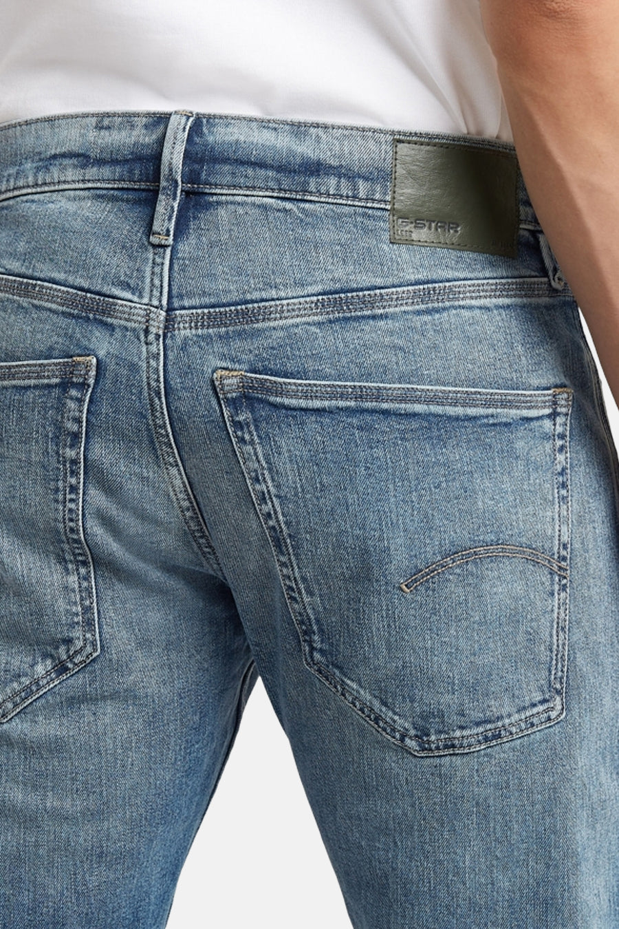 Jean fuselé en denim bleu de G-Star RAW, avec poches arrière et une étiquette de marque.