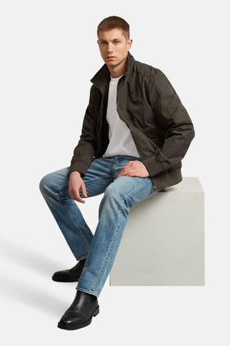 Jean fuselé en denim bleu moyen de G-Star RAW, associé à un t-shirt blanc et des bottes noires.