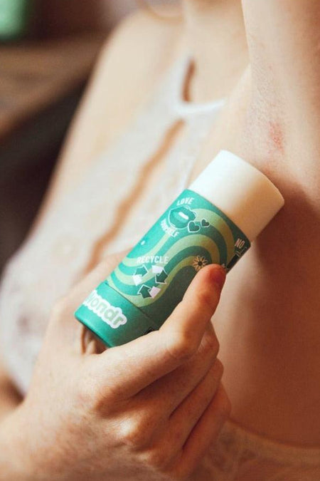 Groene deodorant stick – gember & limoen van WONDR CARE, gebruikt door een vrouw, met 'love yourself' en recycle symbolen.