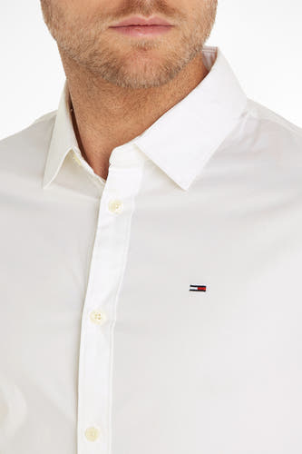 Chemise blanche à manches longues de TOMMY JEANS, avec un petit logo sur la poitrine.